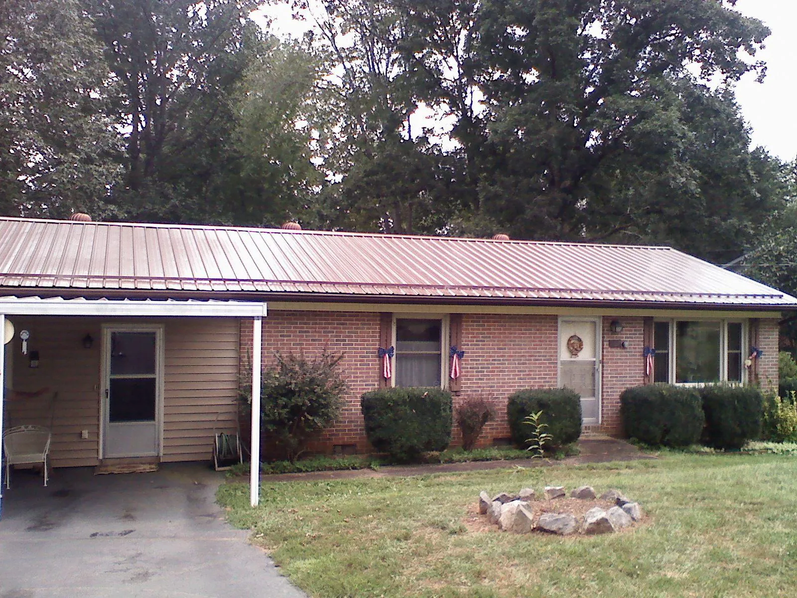 Bronze metal roof and carport on a brick ranch home — Roof Repair work by our crew in Fairview